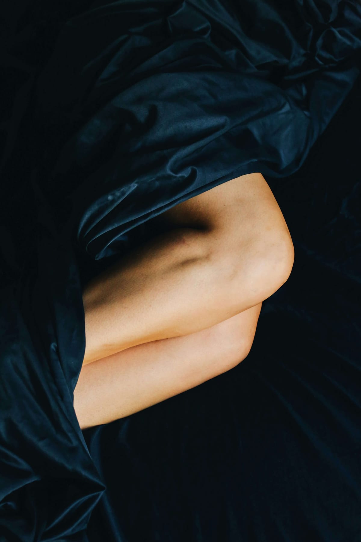 Women legs in silk sheets